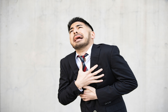 胸を押さえて辛そうな男性